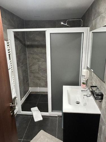 a bathroom with a shower and a sink at Luxeva Events Hotel in Drăgăneşti-Olt