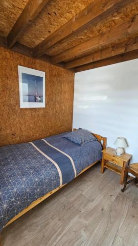 une chambre avec un lit et un parquet dans l'établissement Au bord du lac, à Giffaumont