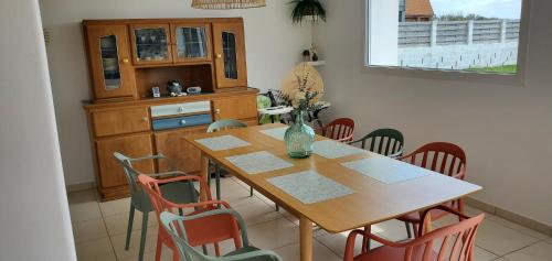 a dining room with a wooden table and chairs at L'abreuvoir de la Mer- villa - plage in Sangatte