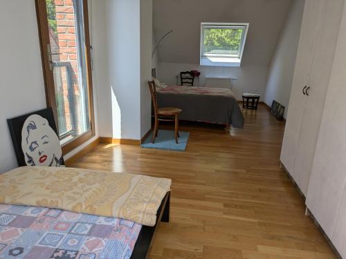 une chambre avec deux lits, une table et une fenêtre dans l'établissement La Pléiade, logement chez l'habitant, à Lille