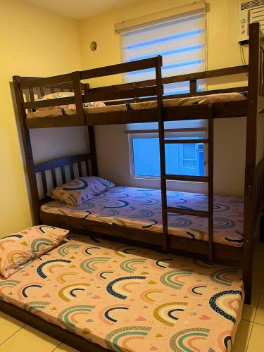 two bunk beds in a room with a rug at URBAN DECA Homes SM EAST Pasig in Manila