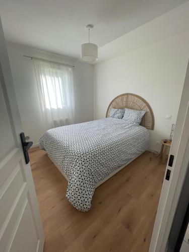 une chambre avec un lit avec une couette noire et blanche dans l'établissement Appartement de Luca, à Saint-André-de-Cubzac