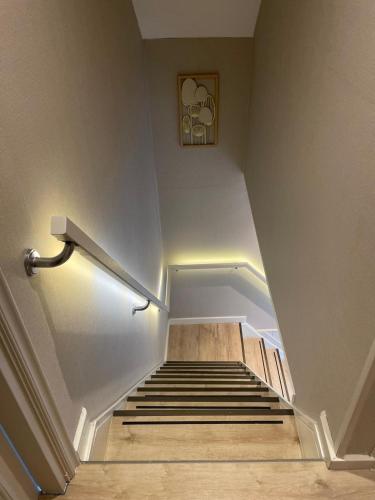 a stairway with a stair railing and a set of stairs with a stair case at Slapen in een eeuwen oude Pastorie in Leermens