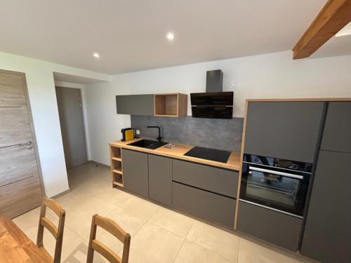 - une cuisine avec un comptoir et une cuisinière four supérieur dans l'établissement LA MARANA - 1 minute des plages - Proche BASTIA AEROPORT - T2 entièrement neuf avec cuisine équipée, à Lucciana