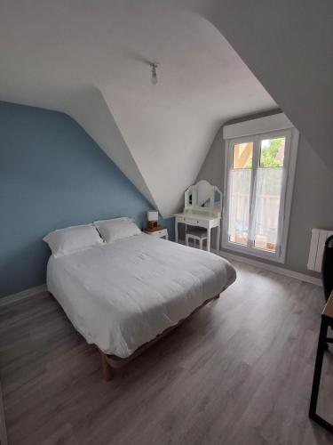 une chambre avec un grand lit blanc et une fenêtre dans l'établissement Leroi, à Fay