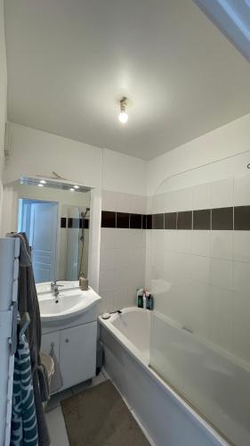 une salle de bain blanche avec une baignoire et un lavabo dans l'établissement Appartement de Luca, à Saint-André-de-Cubzac