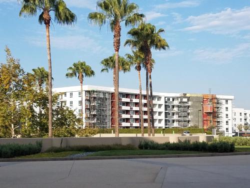 a large apartment building with palm trees in the background at Penthouse Dreams in Irvine