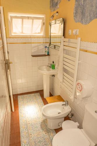 a bathroom with a white toilet and a sink at Hostel Albergue La Casa Encantada in El Paso
