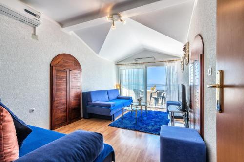 a living room with a blue couch and a table at Villa Roses Apartments & Wellness in Ičići