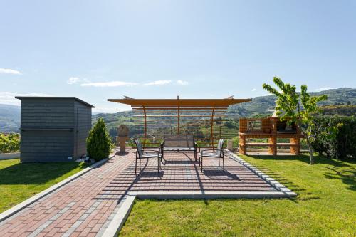 a patio with a table and chairs and a gazebo at Ladeira Suites, a Douro Retreat by HostWise in Santa Marinha do Zêzere