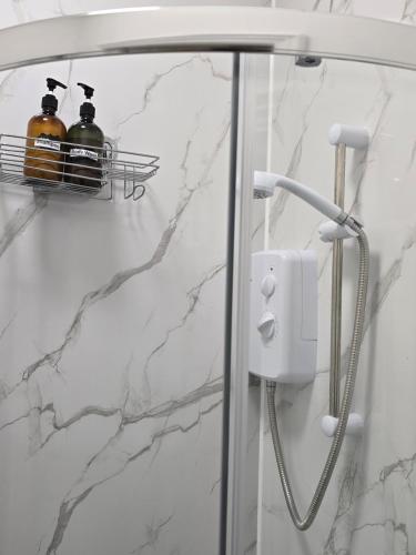 a shower with two bottles of soap in a bathroom at Ivy on Sea Villa in Southend-on-Sea