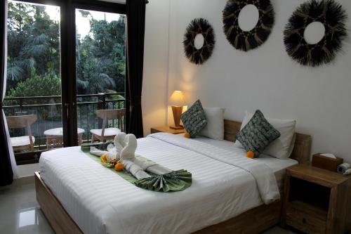 Postel nebo postele na pokoji v ubytování Hanaka Riverside Ubud