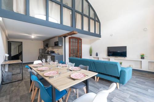 ein Esszimmer mit einem Tisch und blauen Stühlen in der Unterkunft Le Château Fort 16 in Albertville