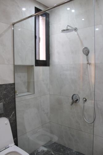 a bathroom with a glass shower with a toilet at Villa Bakhta in Najem