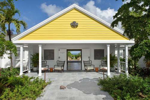 a yellow and white house with a patio at Rosewood Le Guanahani St Barth in Marigot