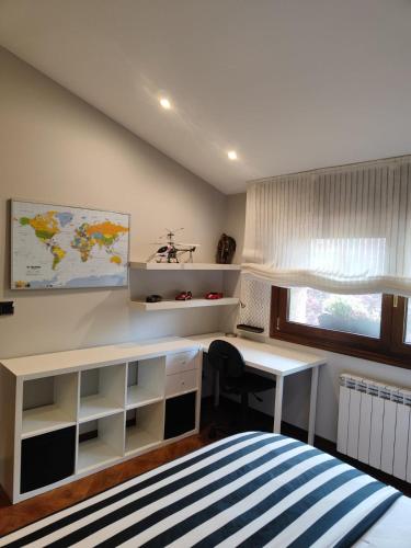 a bedroom with a desk and a bed and a window at O Piñón in Santa Cristina de Cobres