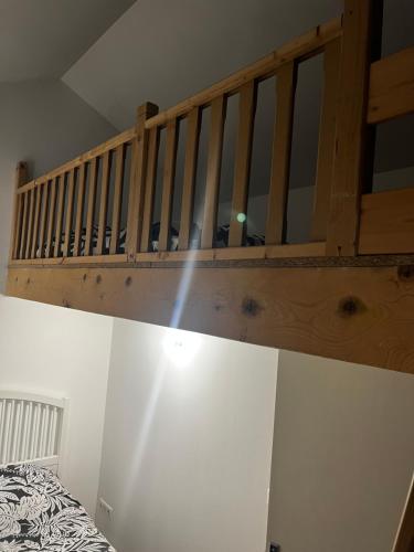 - un escalier en bois dans une chambre avec un lit dans l'établissement La Maison Téranga au Bourg de Villenave, à Courrejean
