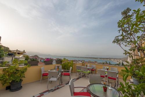 a balcony with tables and chairs and a view of the ocean at Amfitriti Palazzo in Nafplio