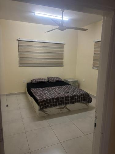 a bedroom with a bed and a ceiling fan at Bubbles in Jurf ad Darāwīsh
