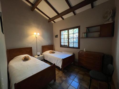 a bedroom with two beds and a window at Petite maison provençale pour 4 personnes in Bormes-les-Mimosas