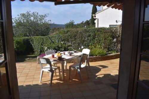 une table et des chaises assises sur une terrasse dans l'établissement Petite maison provençale pour 4 personnes, à Bormes-les-Mimosas