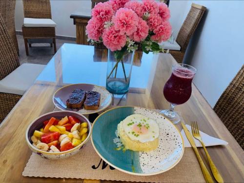 een tafel met borden en een vaas met bloemen bij Hotel Boutique Olas Marinas Luxury in Santa Marta