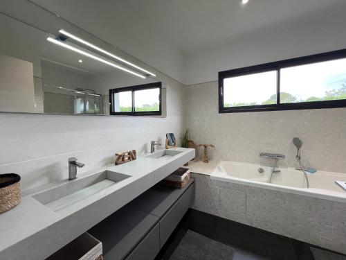 une salle de bain avec deux lavabos et une baignoire dans l'établissement Villa 