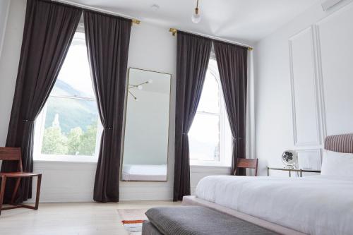 a bedroom with a bed and two large windows at The Wyman Hotel in Silverton