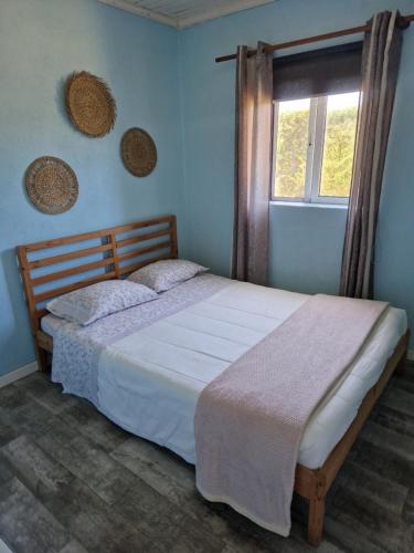 Un dormitorio con una cama grande con ventana. en Casa do Baixio, en Faja Grande