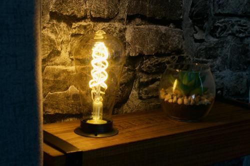 a lit lamp sitting on a table next to a vase at Elegantes Business Apartment in Lorsch