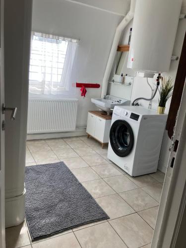 a laundry room with a washing machine and a sink at Gaby's House in Liège