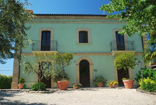 a green house with potted plants in front of it at Agriturismo Villa Vetiche in Rocca San Giovanni