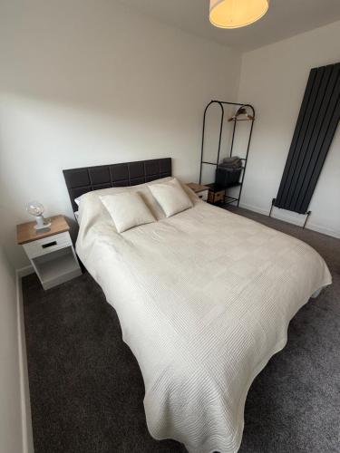 a bedroom with a large white bed and a night stand at Taunton Retreat in Wilton