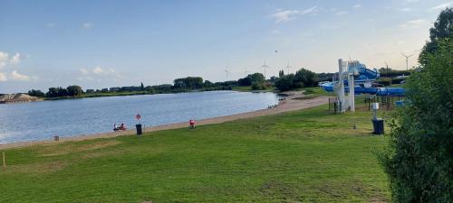 a beach next to a body of water with a plane at Lipperose in Lathum