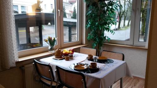 ブラウンラーゲにあるUrlaubsOase Braunlageの白いテーブルクロスと果物を添えたテーブル