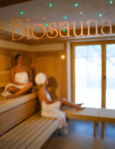 two women sitting on benches in a boat at Apart Hotel Garni Strasser in Zell am Ziller