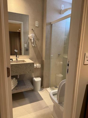 a bathroom with a toilet and a sink and a shower at Ouro Cerrado Palace Hotel in Patrocínio