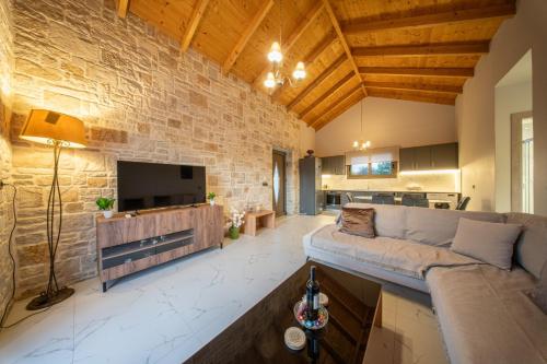a living room with a couch and a tv at Blue Private Stone Villa Skala in Skala Kefalonias