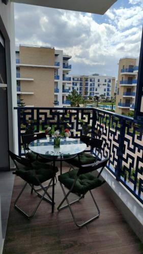 a table and chairs on the balcony of a building at Appartement costamar à 200m de la plage in Martil