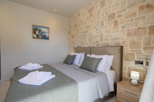 a bedroom with a bed and a stone wall at Blue Private Stone Villa Skala in Skala Kefalonias