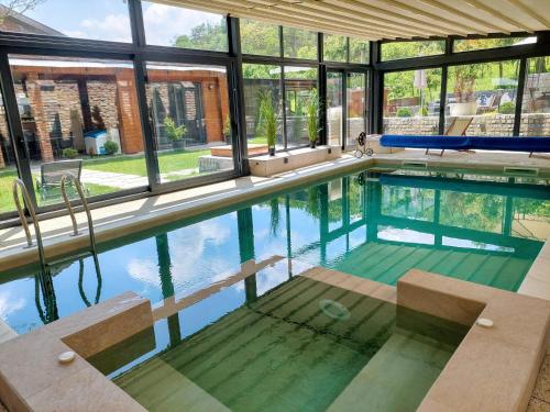 an indoor swimming pool with a large window at Vila MP Banstol 4*- Brdež do, Fruška gora in Inđija