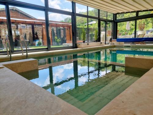 a swimming pool in a house with windows at Vila MP Banstol 4*- Brdež do, Fruška gora in Inđija
