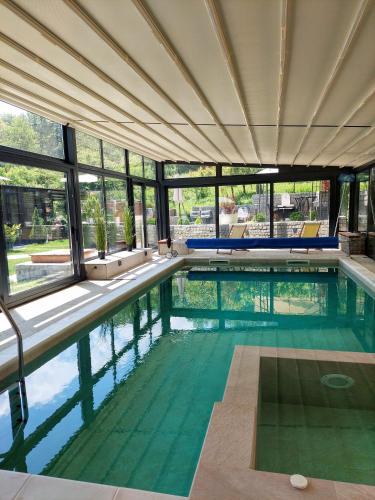 a swimming pool in a building with windows at Vila MP Banstol 4*- Brdež do, Fruška gora in Inđija