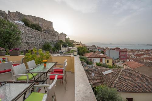 a balcony with tables and chairs and a view of the city at Amfitriti Palazzo in Nafplio