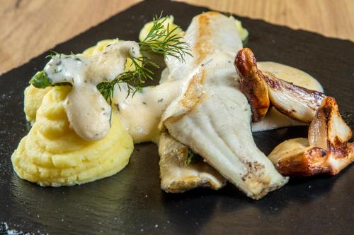 a plate of food with chicken and potatoes on a table at Hotel Logos in Zakopane
