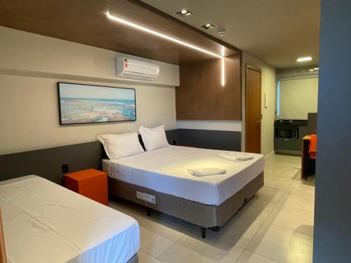 a hotel room with two beds and a kitchen at Easy Porto Hotel in Porto De Galinhas