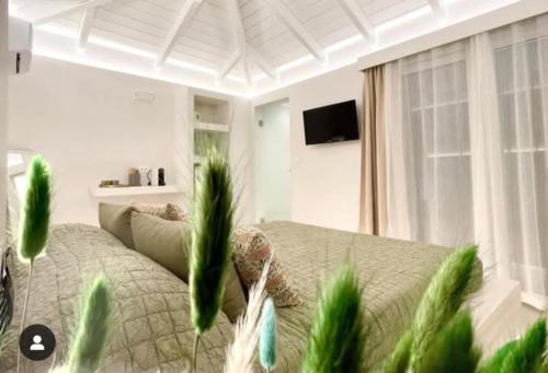 a bedroom with a bed with green plants in it at White House Luxury Apartment of Rhodes in Kremasti