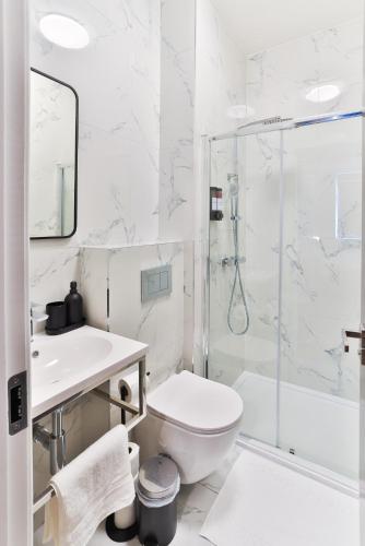 a white bathroom with a toilet and a shower at Finsbury Rose in London