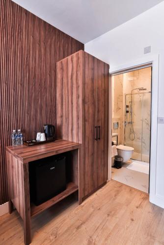 a bathroom with a wooden cabinet next to a toilet at Finsbury Rose in London