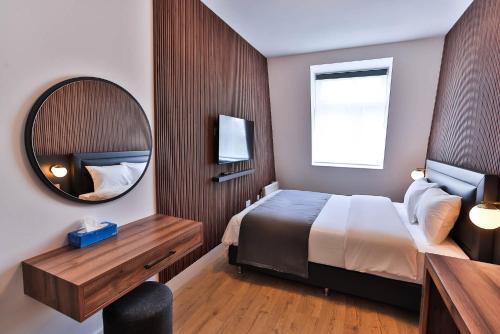 a hotel room with a bed and a mirror at Finsbury Rose in London